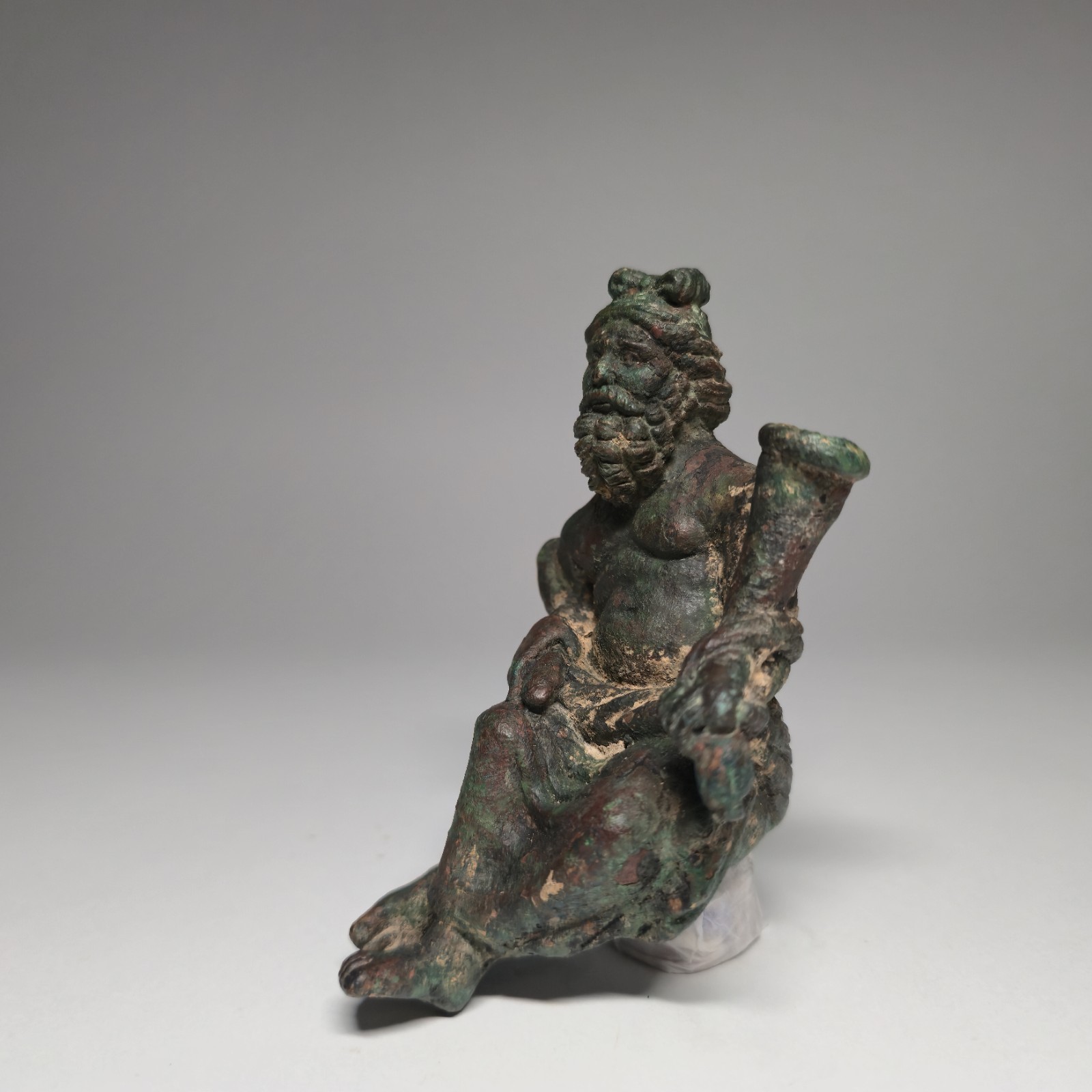 AN IMPORTANT ROMAN BRONZE STATUE OF A SEATED BEARD MAN HOLDING VESSEL. AN IMPORTANT ROMAN BRONZE STATUE OF A SEATED BEARD MAN HOLDING VESSEL.